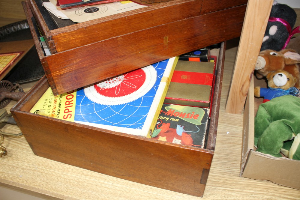 A quantity of assorted toys and games in a stacking three tier box